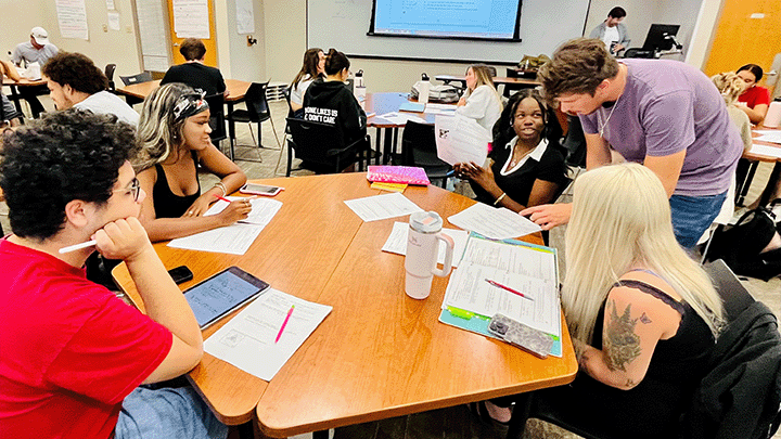 A group of students working together with an LA