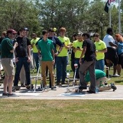Group of FGCU students participating in an outdoor group class exercise.