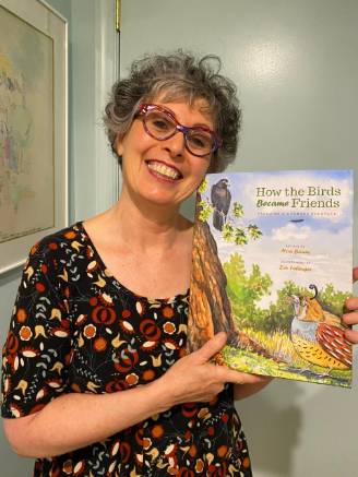 Noa Baum holds a copy of her book /How the birds became friends/