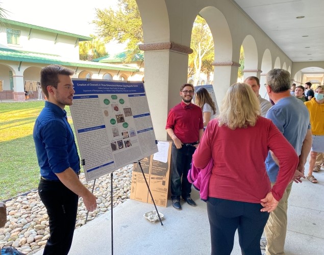 FGCU students presenting research poster to audience