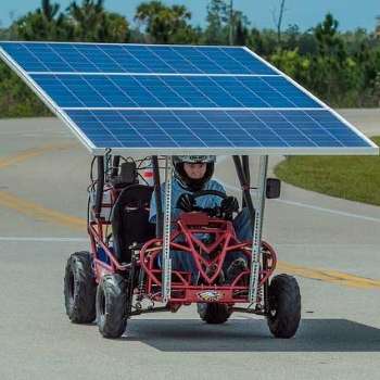 Picture of a young man driving a solar powered go kart.