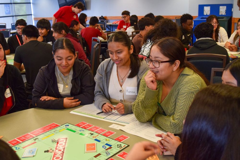 Students playing Monopoly to learn about the basics of accounting
