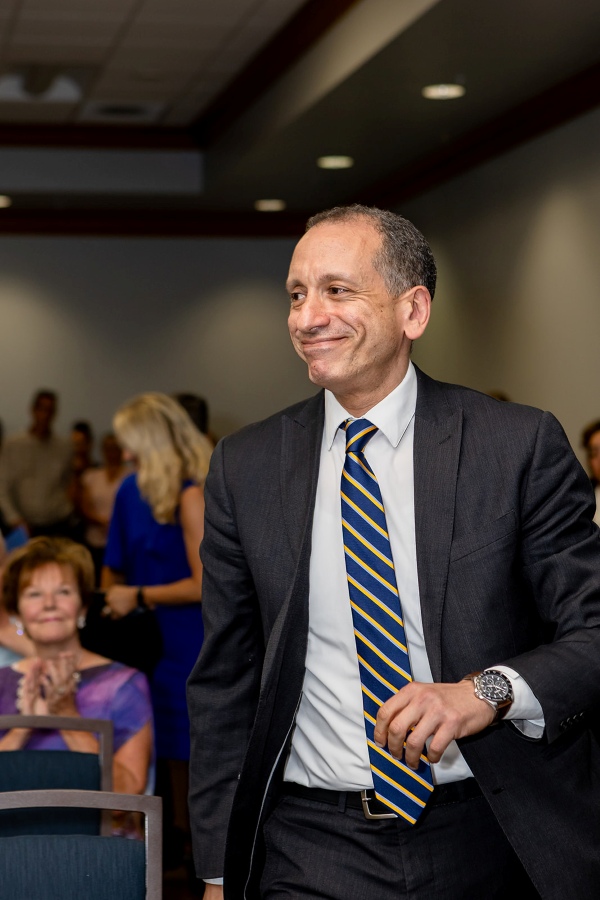 Dr. Khaled Aboulnasr walks toward the stage to receive the Student Success Champion Award during the FGCU Excellence Awards ceremony.