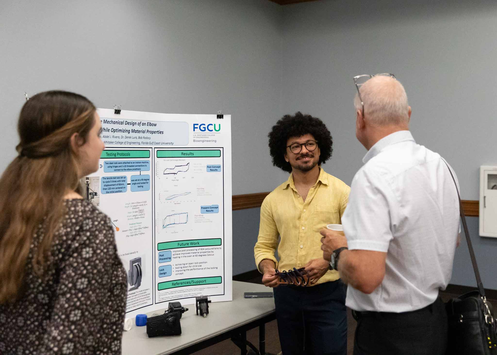 Bioengineering student with curly hair talks about his senior project to a judge.