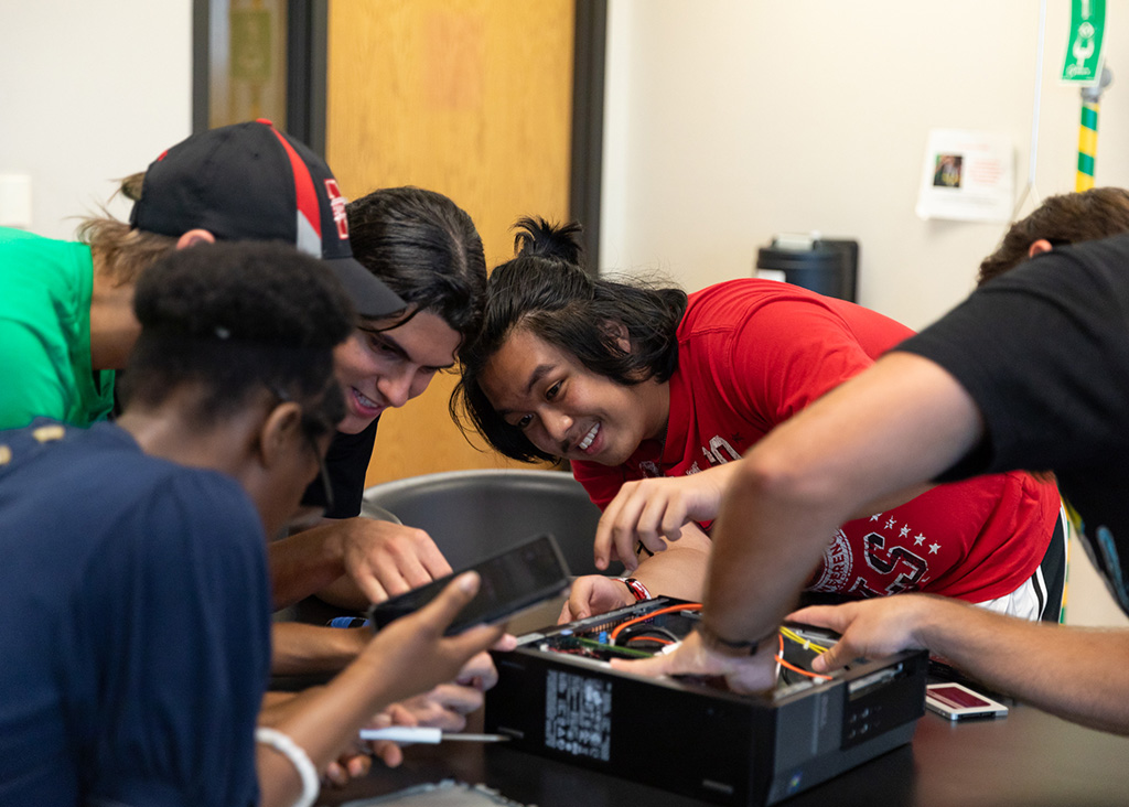 A group of students work together to identify parts of a PC.