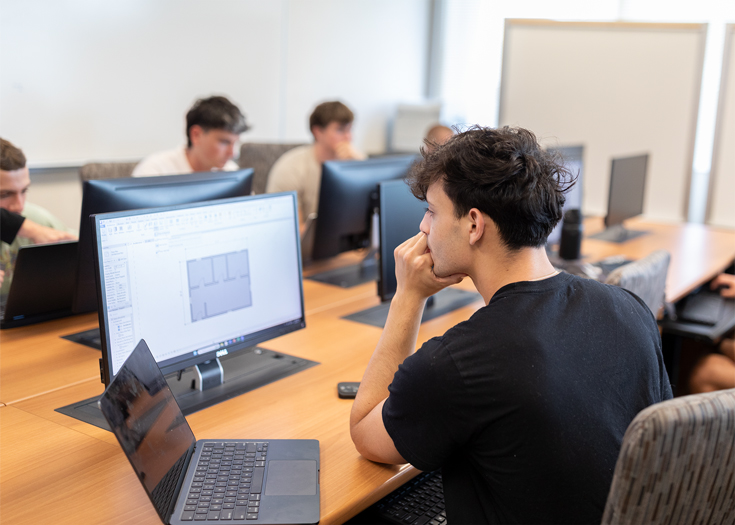 A student looks at a building model on a computer