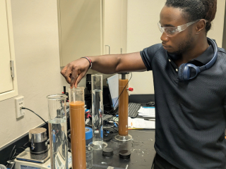 A researcher stirs a substance in a glass tube
