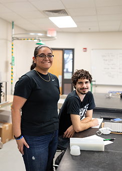 Two students stand near the mold for their concrete golf ball