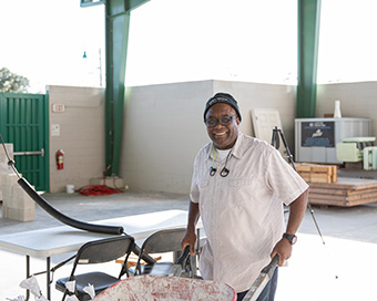 Dr. Villiers smiles while pushing a wheel barrel