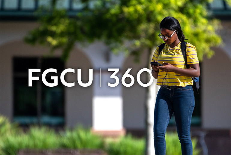 FGCU student walking with a phone on campus