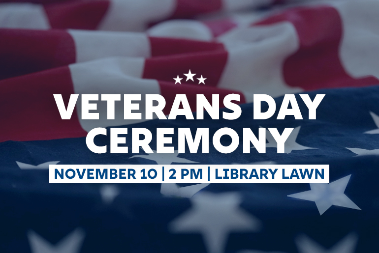 Graphic promoting a Veterans Day Ceremony with a background of a folded American flag. The text reads: 'Veterans Day Ceremony' in bold white letters with three stars above. Below, a blue banner states: 'November 10 | 2 PM | Library Lawn.