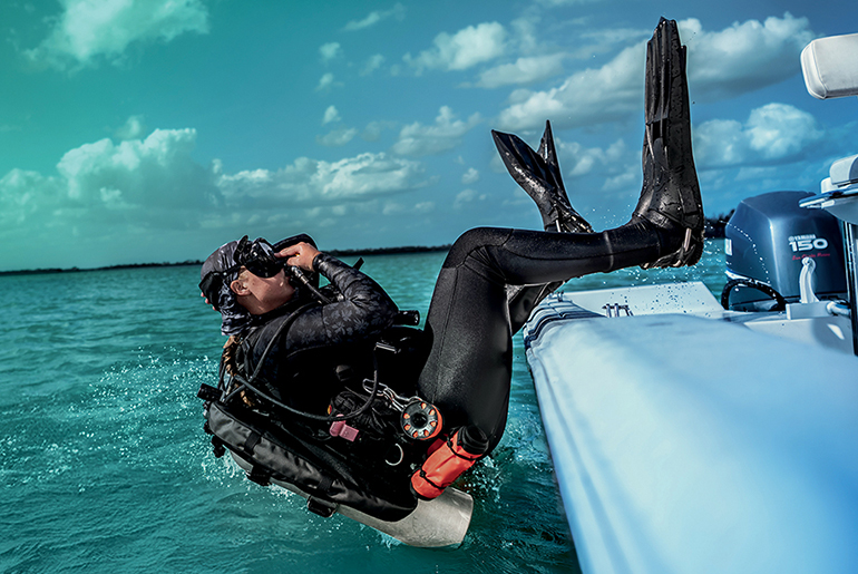 Diver jumping off boat into the ocean