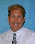 Headshot of Dr. Timothy Ferguson. He is wearing a white button-down shirt and a black tie.