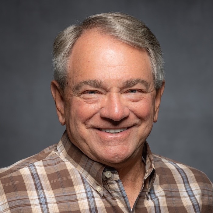 Headshot of Dr. Jon Brunner. He is wearing a brown, beige and blue plaid shirt. 