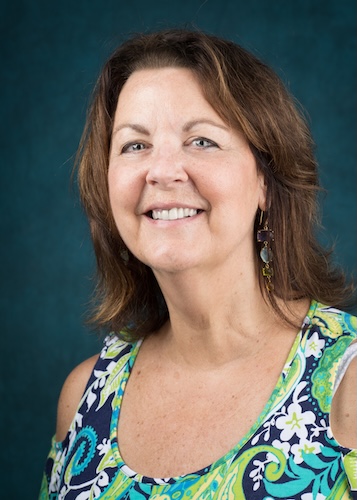 Headshot of Julie Zemplinski. She is wearing a white, blue, and green floral blouse.