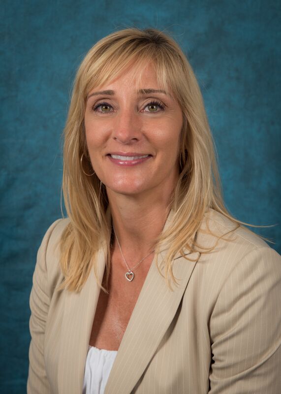 Headshot of Mary Banks. She has short blond hair and is wearing a white blouse underneath a beige jacket.