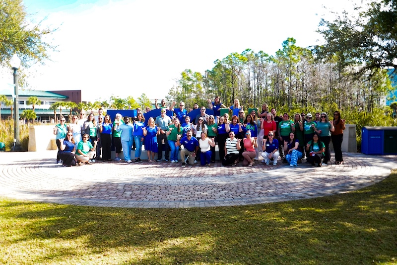 Group photo of FGCU employees at the Library Lawn kicking off the 2025 Soar into Spring kickoff event 