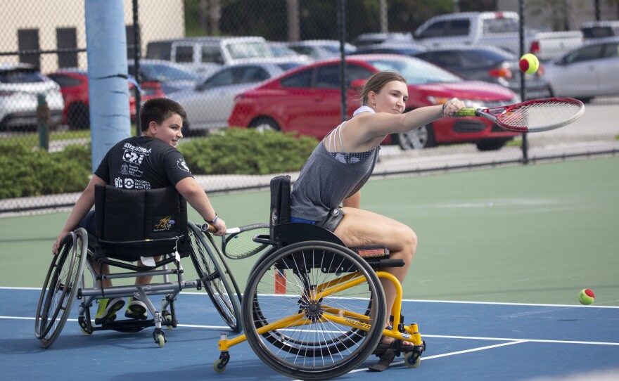 Volunteers playing wheelchair tennis on Adaptive Sports Day