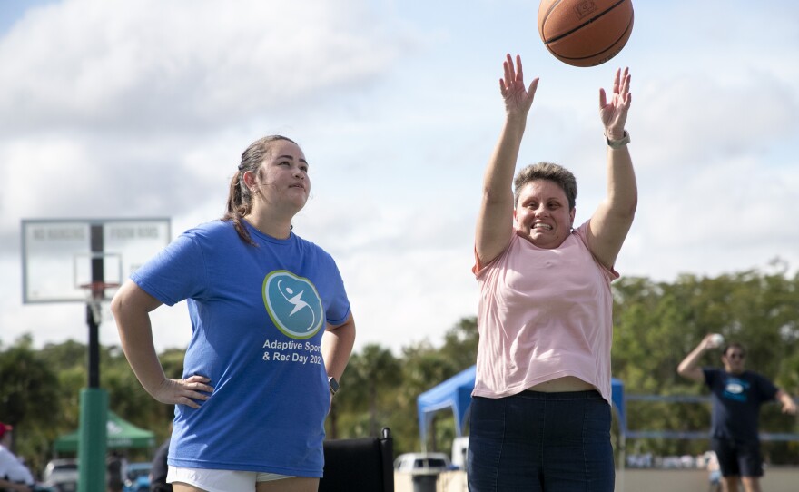 Participant and student volunteer participating in basketball at Adaptive Sports Day 2024