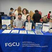 FGCU GIDDI employees standing in front of table at involvement fair 2024