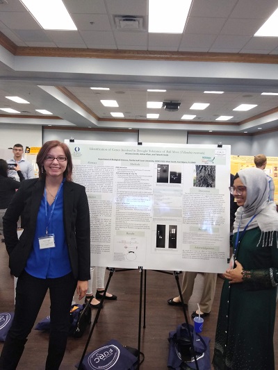 Arianna Smith presenting a poster with another student at a research conference