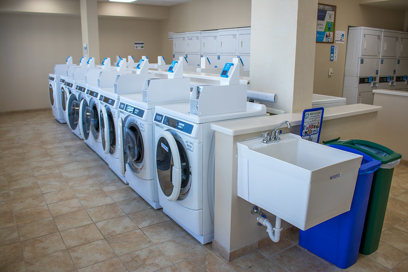 Laundry room with multiple washing machines.