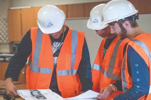 Photo of students looking at design plans Photo of students looking at design plans