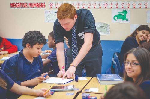 Photo of student assisting K-12 students in the classroom