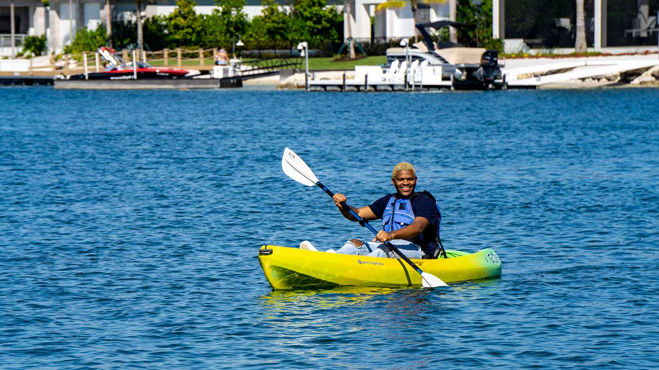person kayaking at waterfront