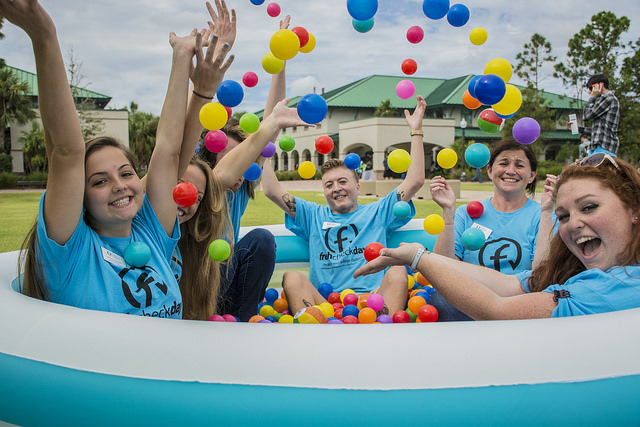 student in ball pit smiling